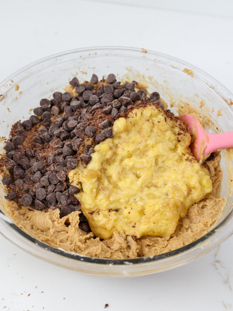 image of overripe banana and chocolate chips being mixed into banana cookie batter