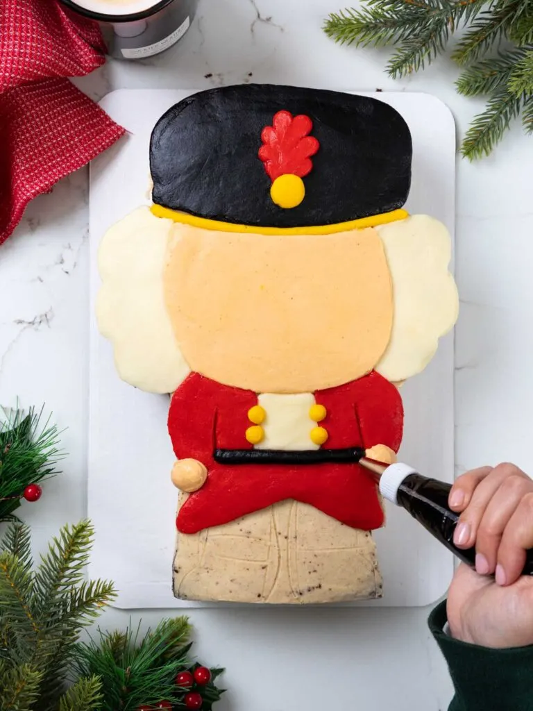 image of buttercream frosting being piped onto a nutcracker sheet cake