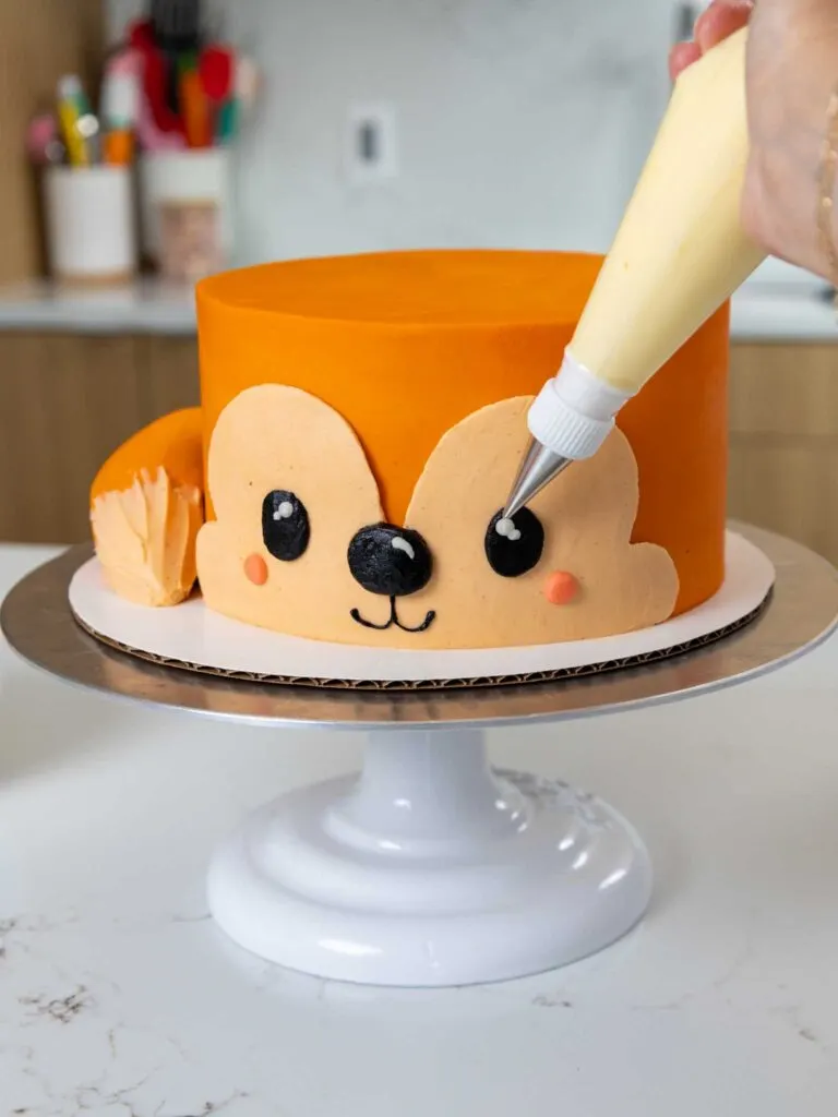 image of a cute fox cake being decorated with buttercream