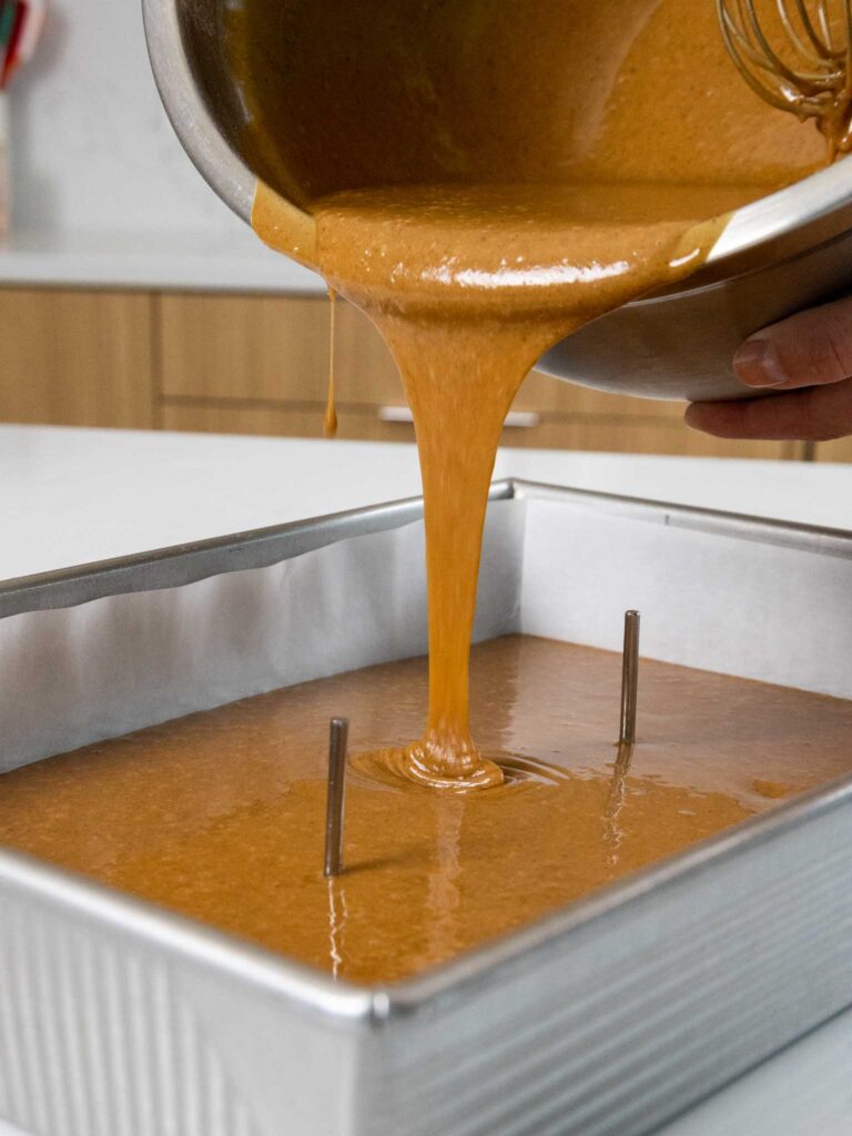 image of gingerbread cake batter being poured into a quarter sheet pan