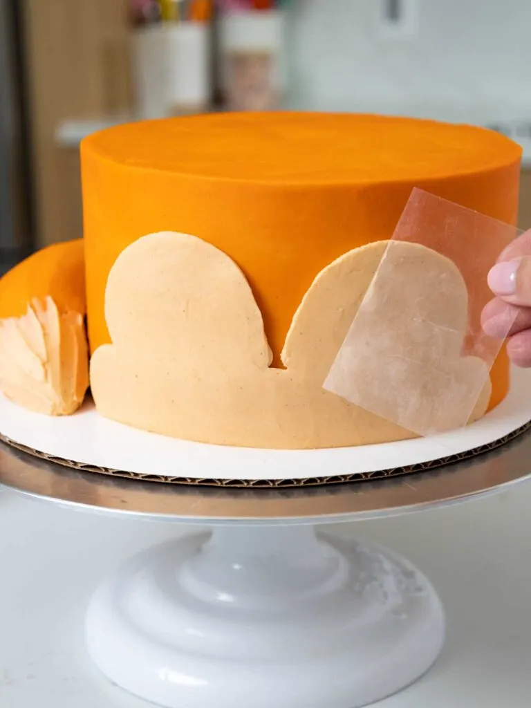 image of light orange frosting being smoothed onto a fox cake