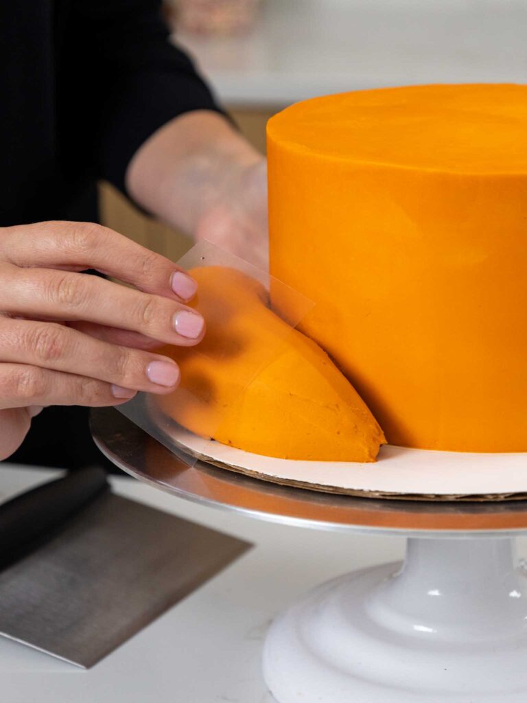 image of orange frosting being smoothed onto a fox cake