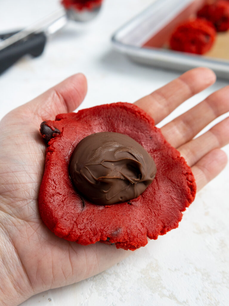 image of a red velvet cookie being stuffed with frozen Nutella