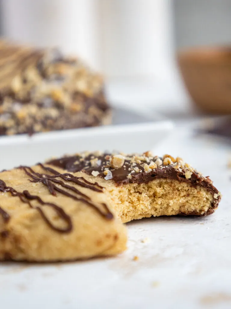 image of a chocolate dipped peanut butter cookie that's been bitten into to show how soft and tender it is