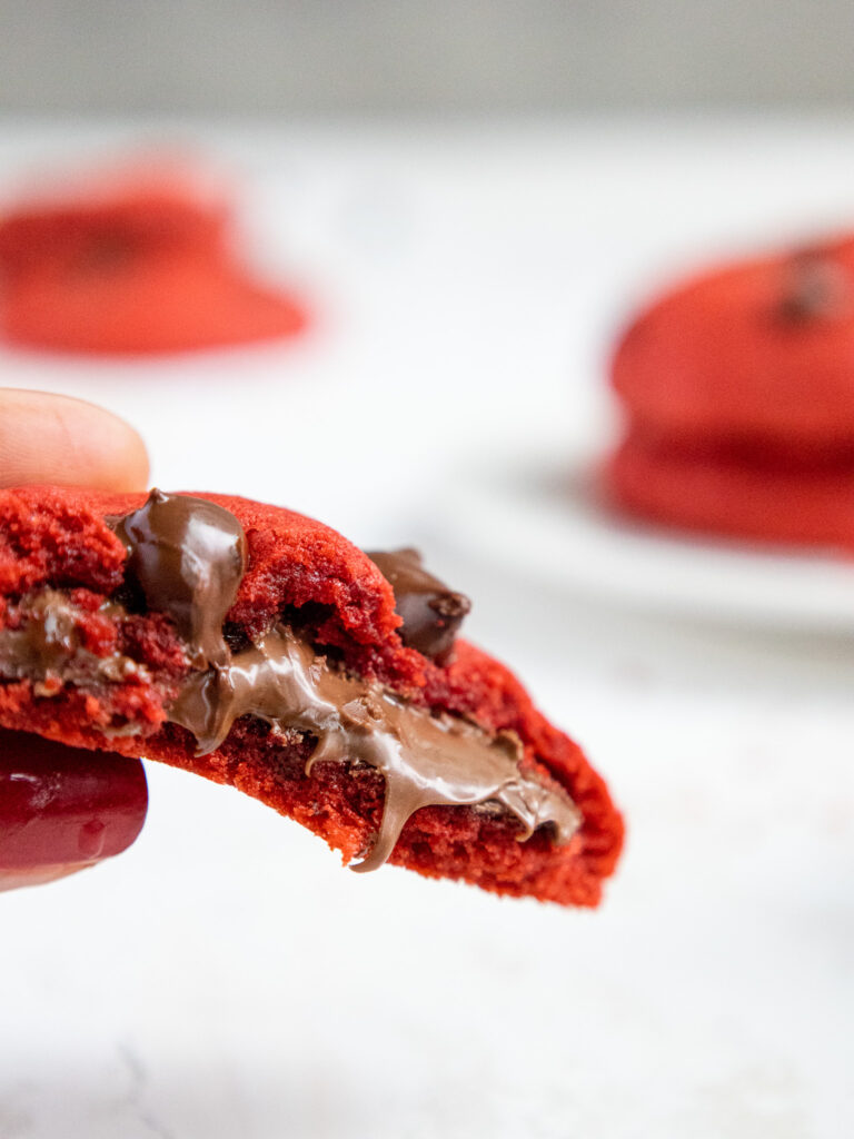 image of a red velvet cookie that's been bitten into to show its Nutella filling