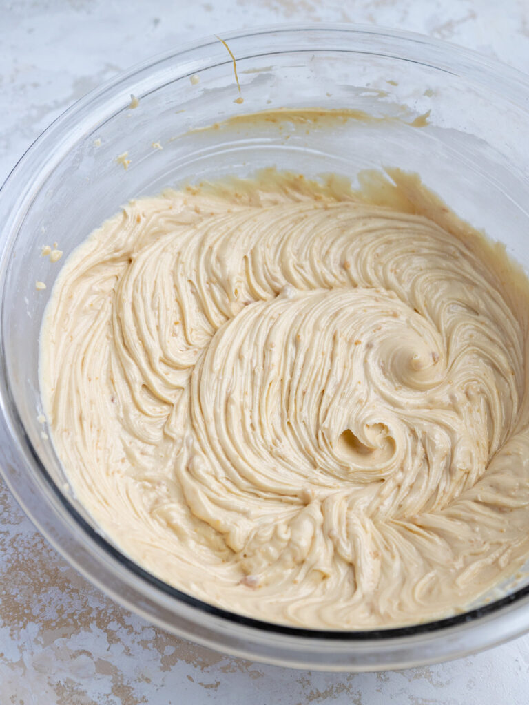 image of caramel buttercream being mixed together in a glass bowl