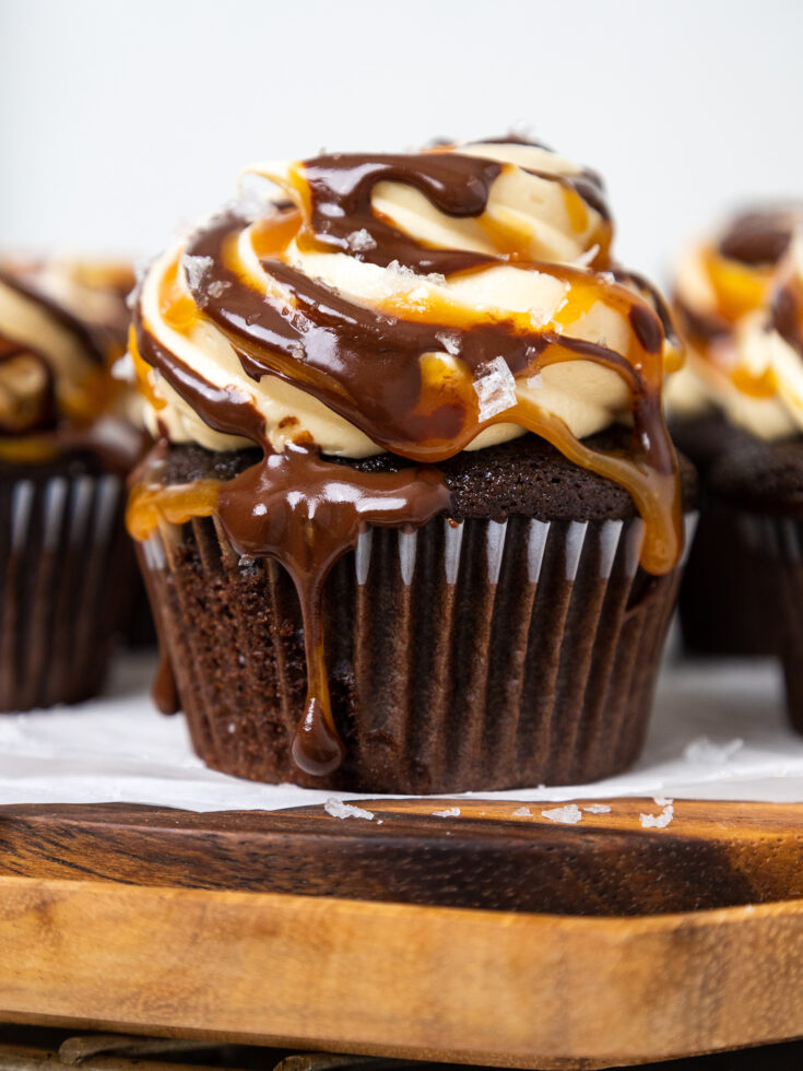 image of a chocolate caramel cupcake that's been drizzled with melted caramel and chocolate ganache