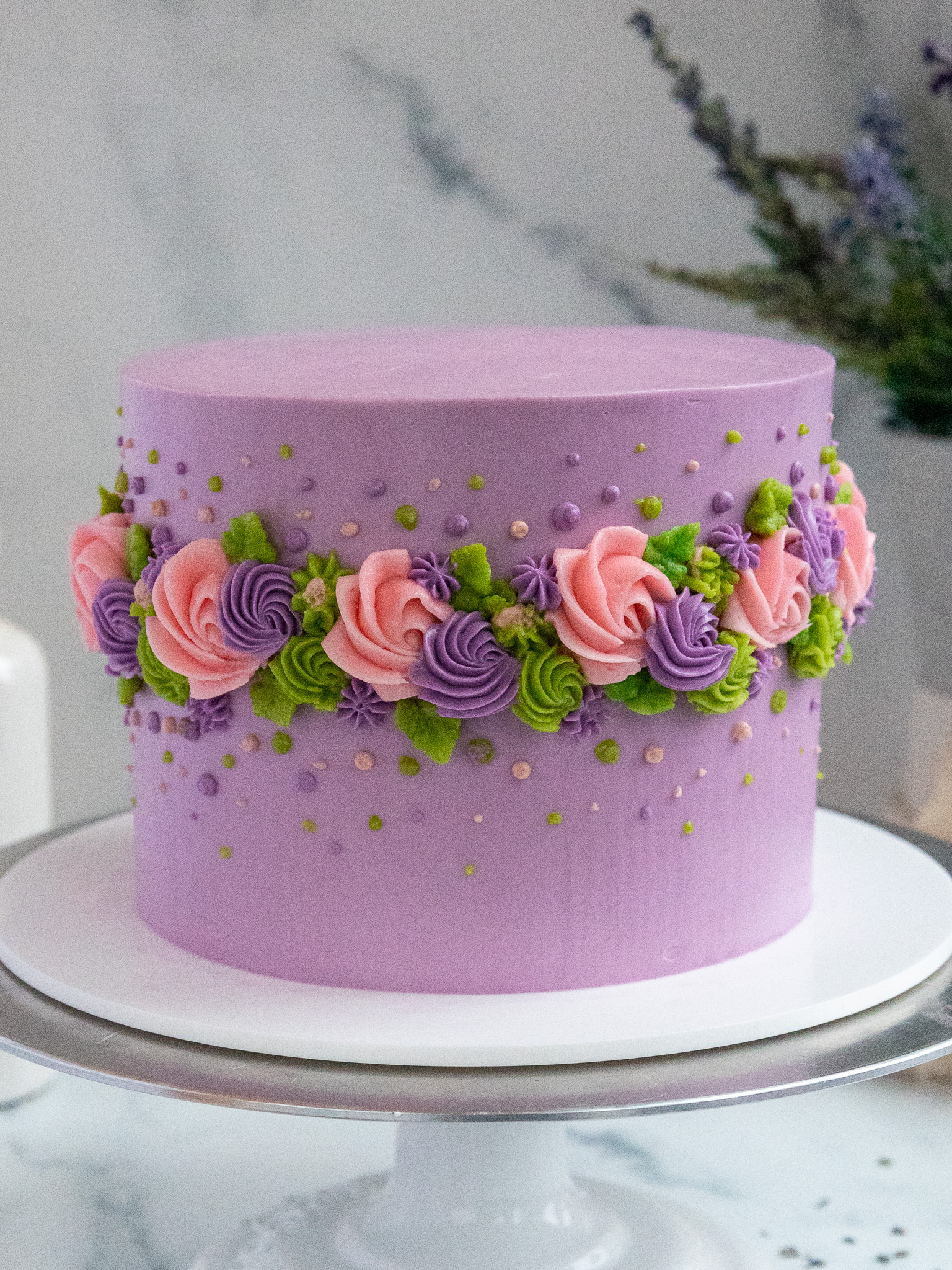 image of an earl grey lavender layer cake decorated with buttercream flowers