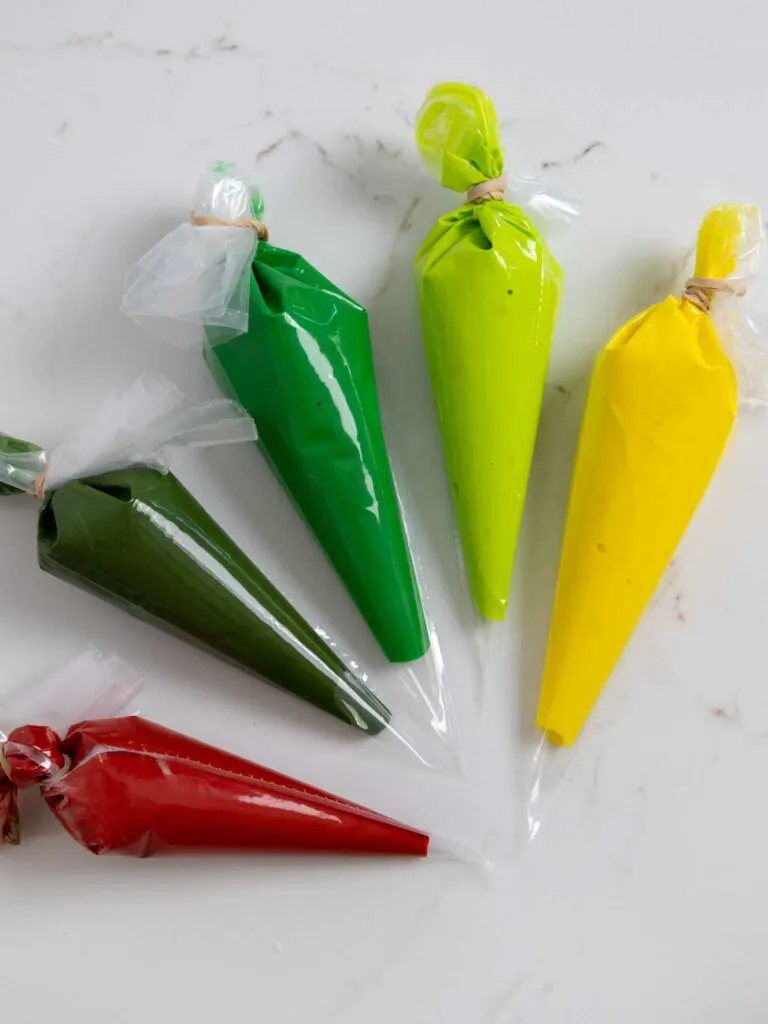 image of royal icing in piping bags that have been colored with gel food coloring