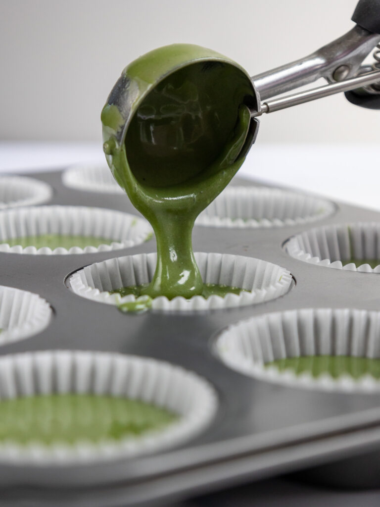 image of matcha cupcake batter being scooped into cupcake liners with a cookie scoop