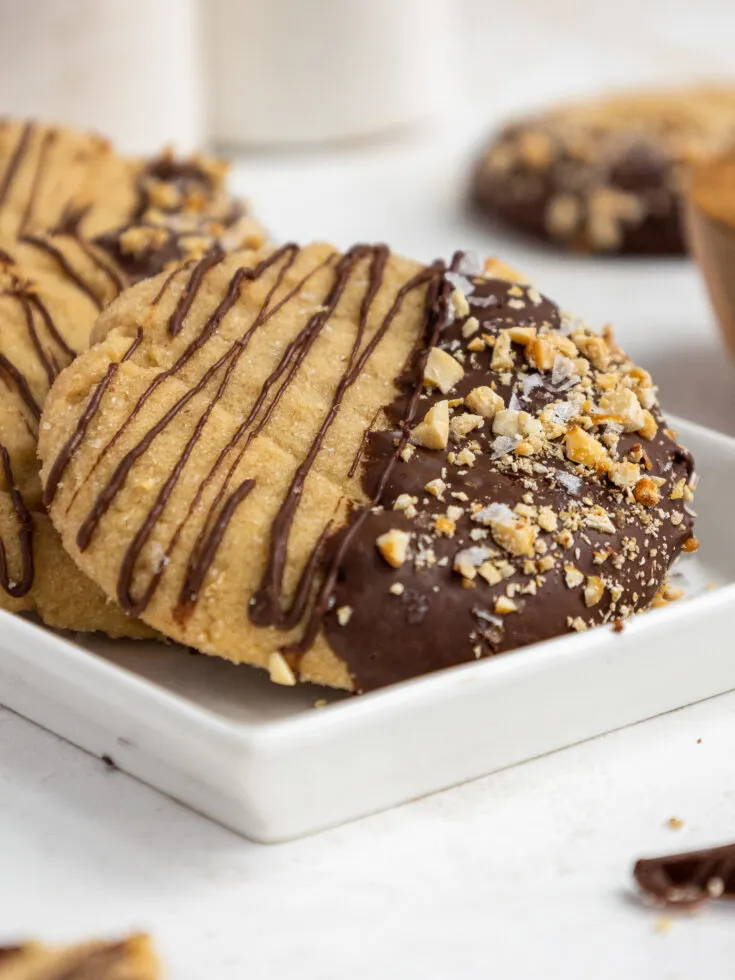 image of melted chocolate being drizzled onto soft batch peanut butter cookies
