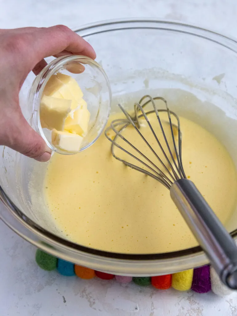 adding small chunks of butter into cooked pineapple curd
