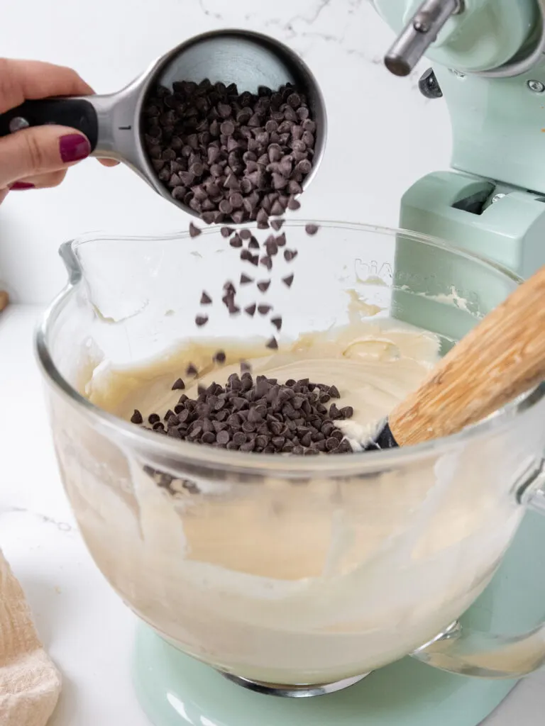 image of mini chocolate chips being added into brown sugar cake layers