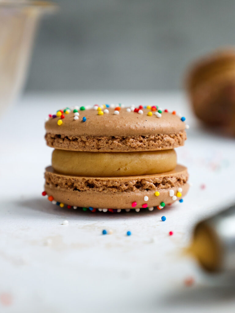image of a chocolate macaron that have been filled with peanut butter ganache