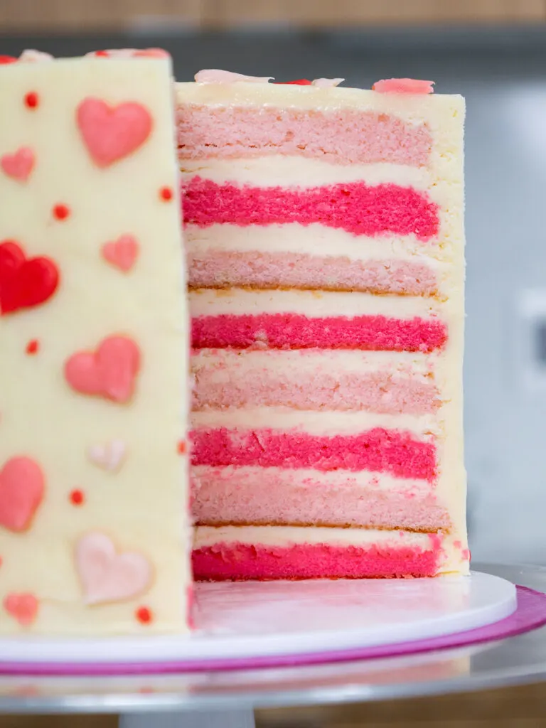 image of a cake that's been cut into to show it's pretty pink velvet cake layers
