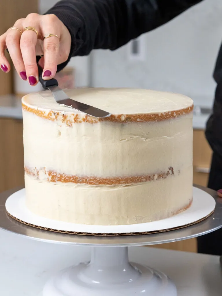image of a cake being crumb coated with brown sugar buttercream