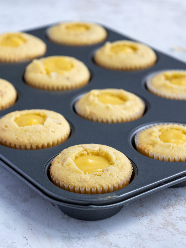 coconut cupcakes that have been filled with pineapple curd