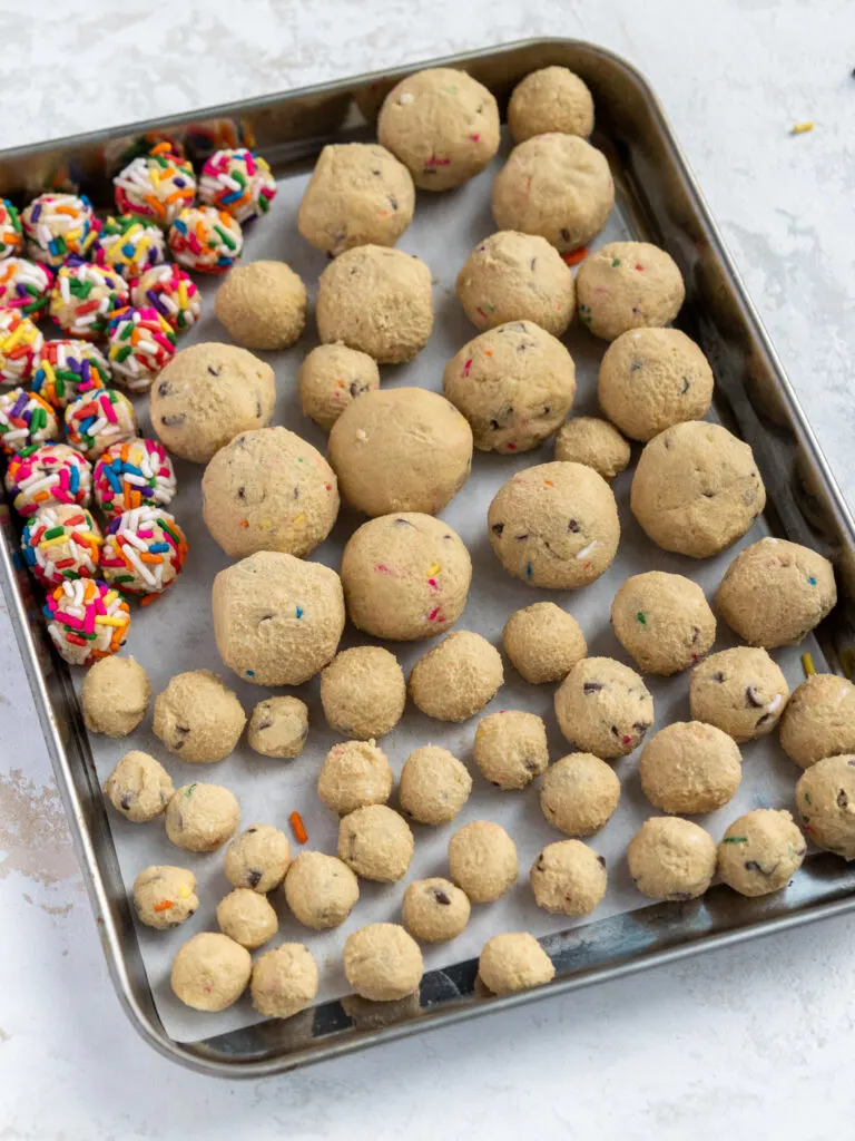 image of edible cookie dough balls that have been rolled out and placed on a metal tray