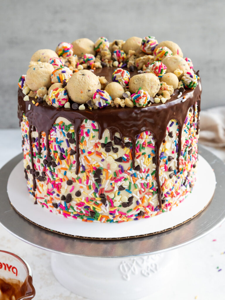 image of a cookie dough cake that's been decorated with edible cookie dough and sprinkles