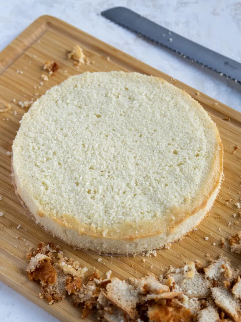 image of a vanilla bean cake layer being leveled and trimmed 