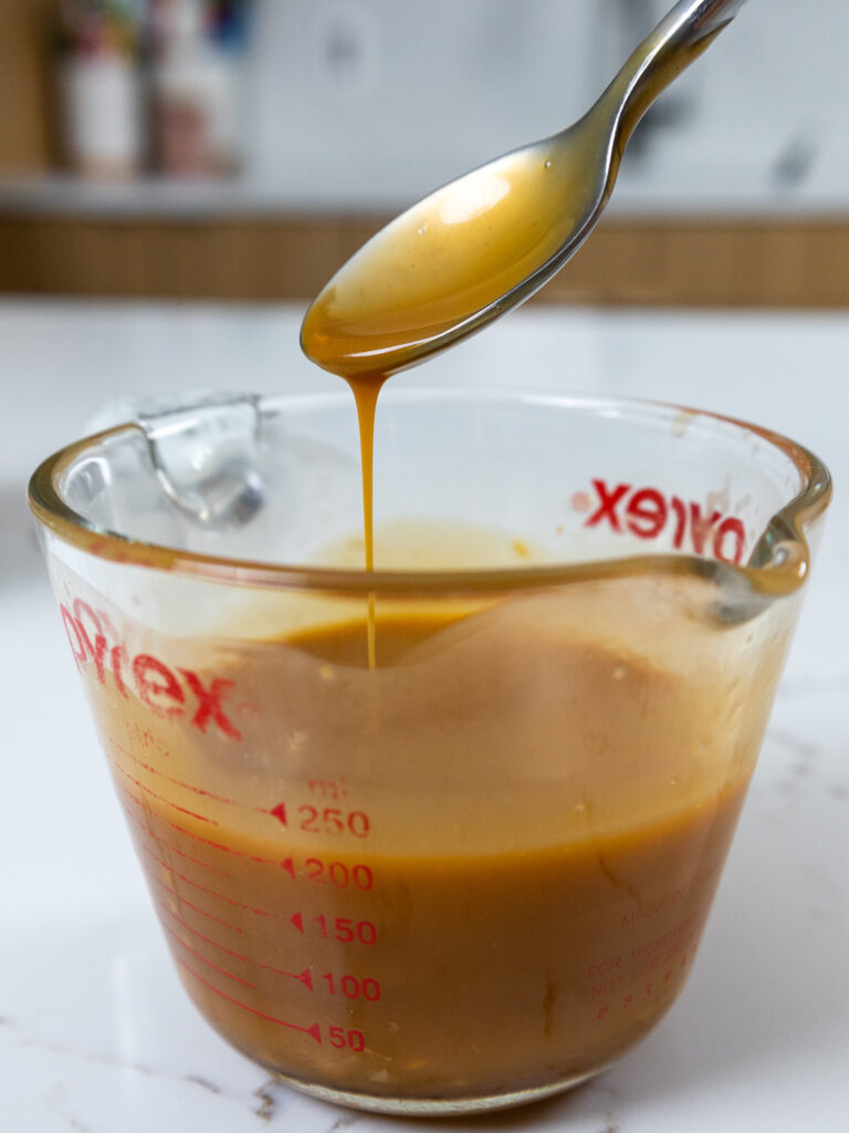 image of butterscotch ganache that's being mixed together in a glass container