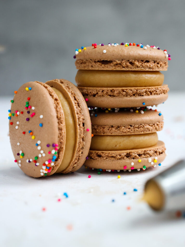 image of chocolate macaron shells that have been filled with peanut butter ganache