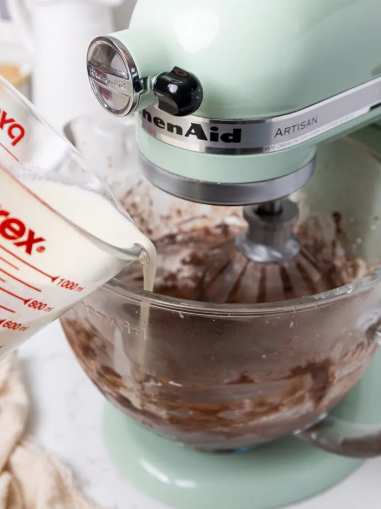 image of heavy cream being poured into a stand mixer bowl to 