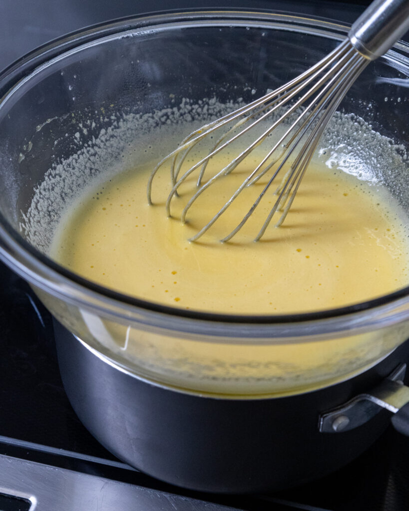 pineapple curd that has been cooked over a double boiler and has become lighter in color as it cooks