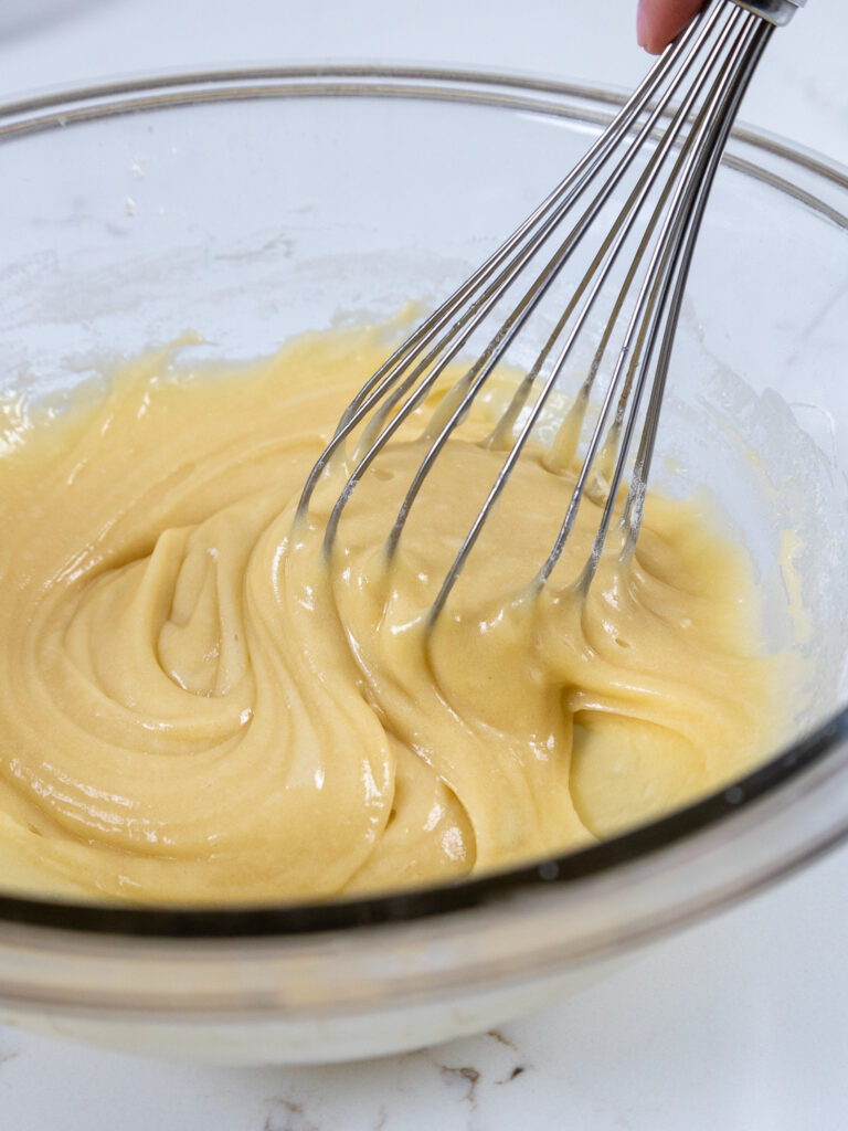 image of banana bread batter being whisked together in a glass bowl