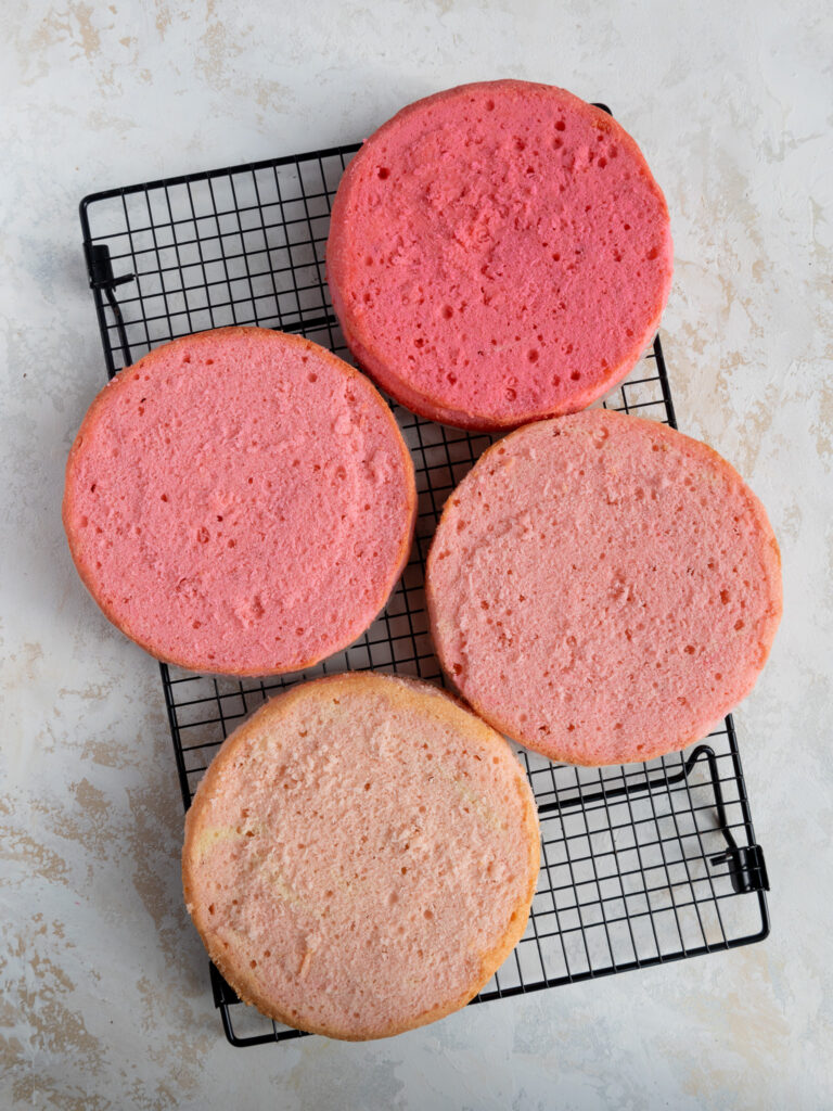 baked pink ombre cake layers that have been trimmed and leveled with a serrated