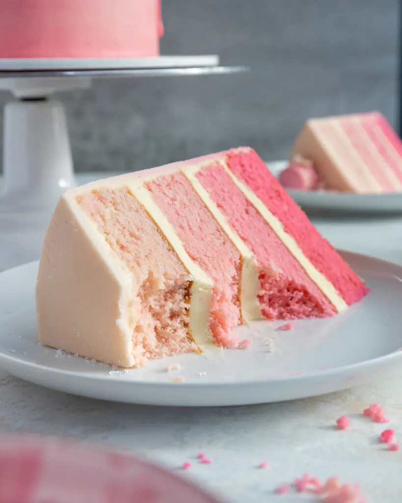 image of slice of pink ombre cake that's been cut into to show how tender and moist the cake layers