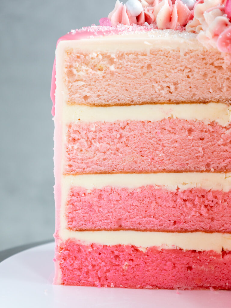 cross section of a pink ombre cake that's been cut into to show it's pretty cake layers