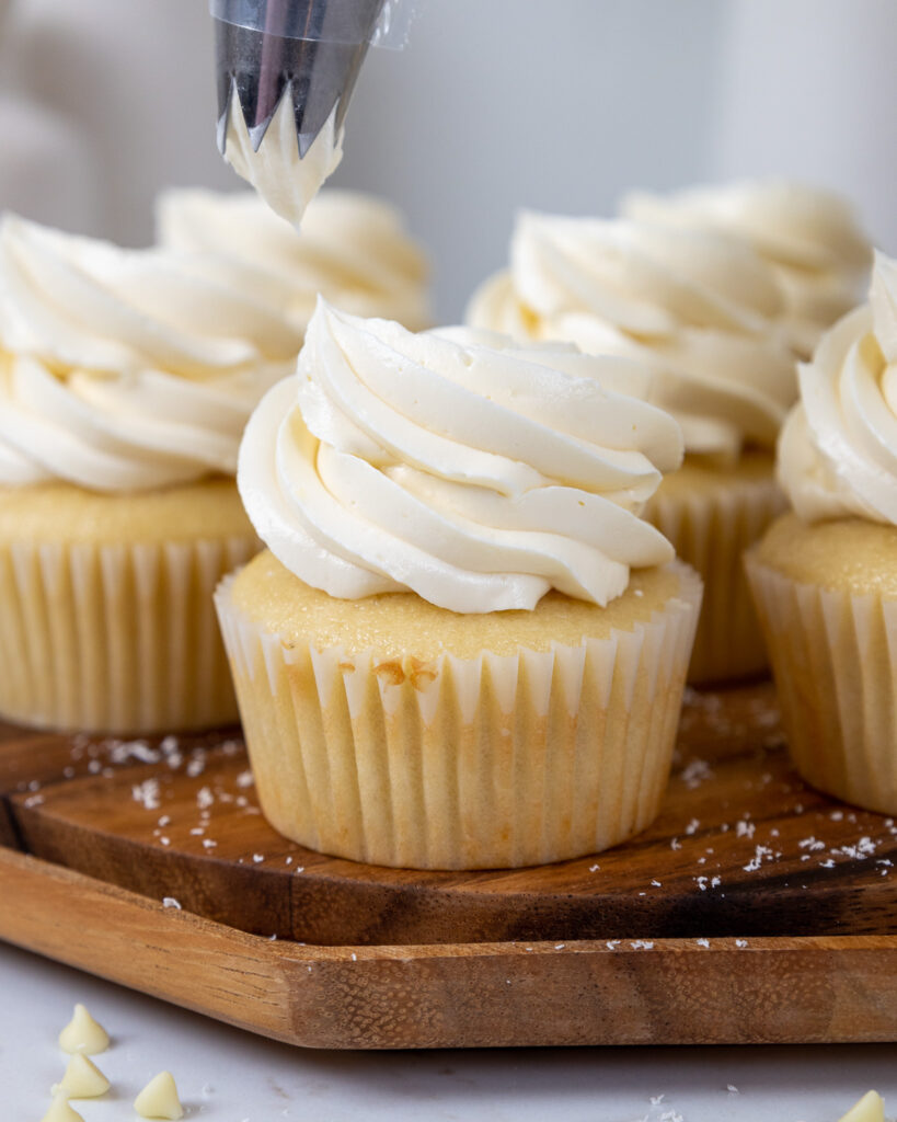 image of cupcakes being frosted with white chocolate Swiss meringue buttercream