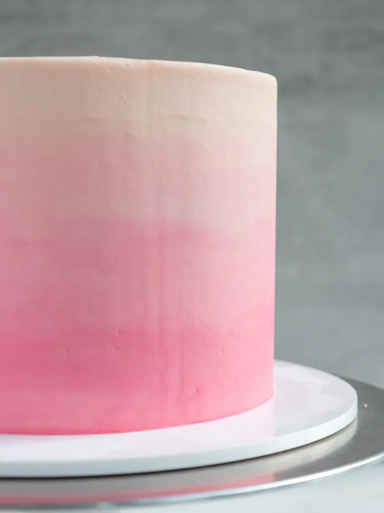 image of a cake that's been frosted with smooth pink ombre buttercream