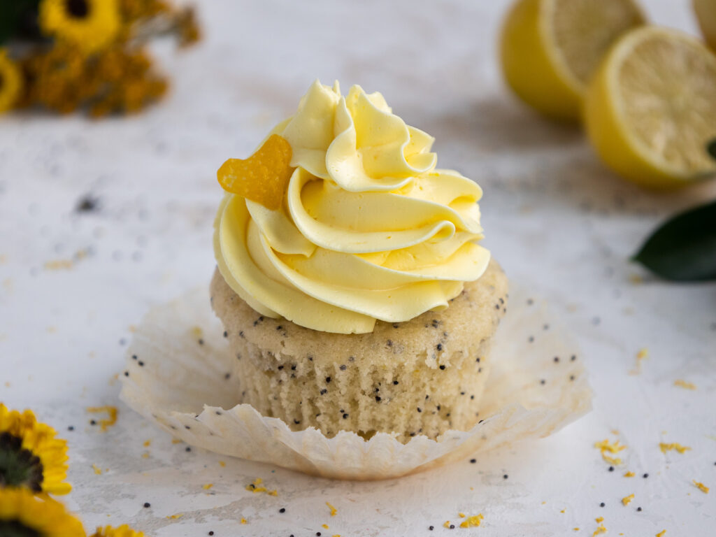 image of a poppy seed cupcake that's been frosted with lemon Swiss meringue buttercream