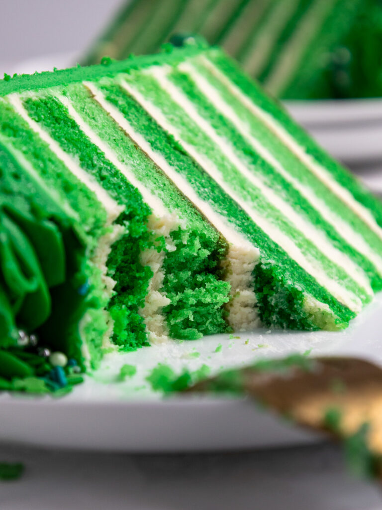 image of a slice of green velvet cake that's been cut into to show how tender the cake layers are
