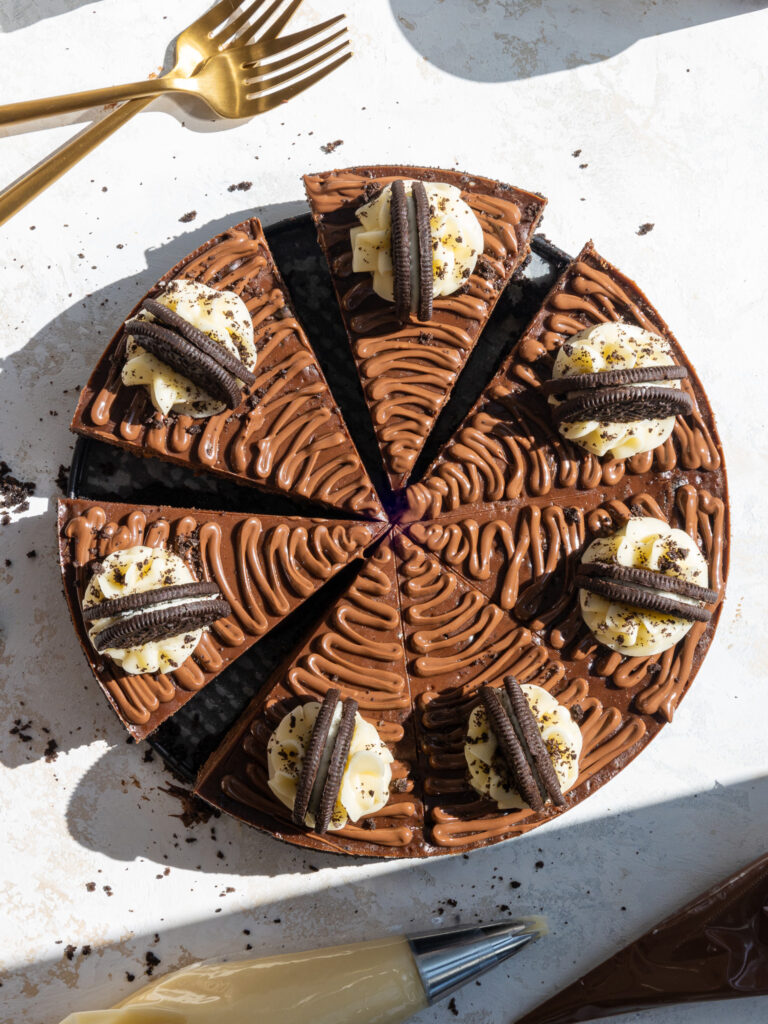 image of a Nutella Oreo Cheesecake that's been cut into and a slice is being pulled from