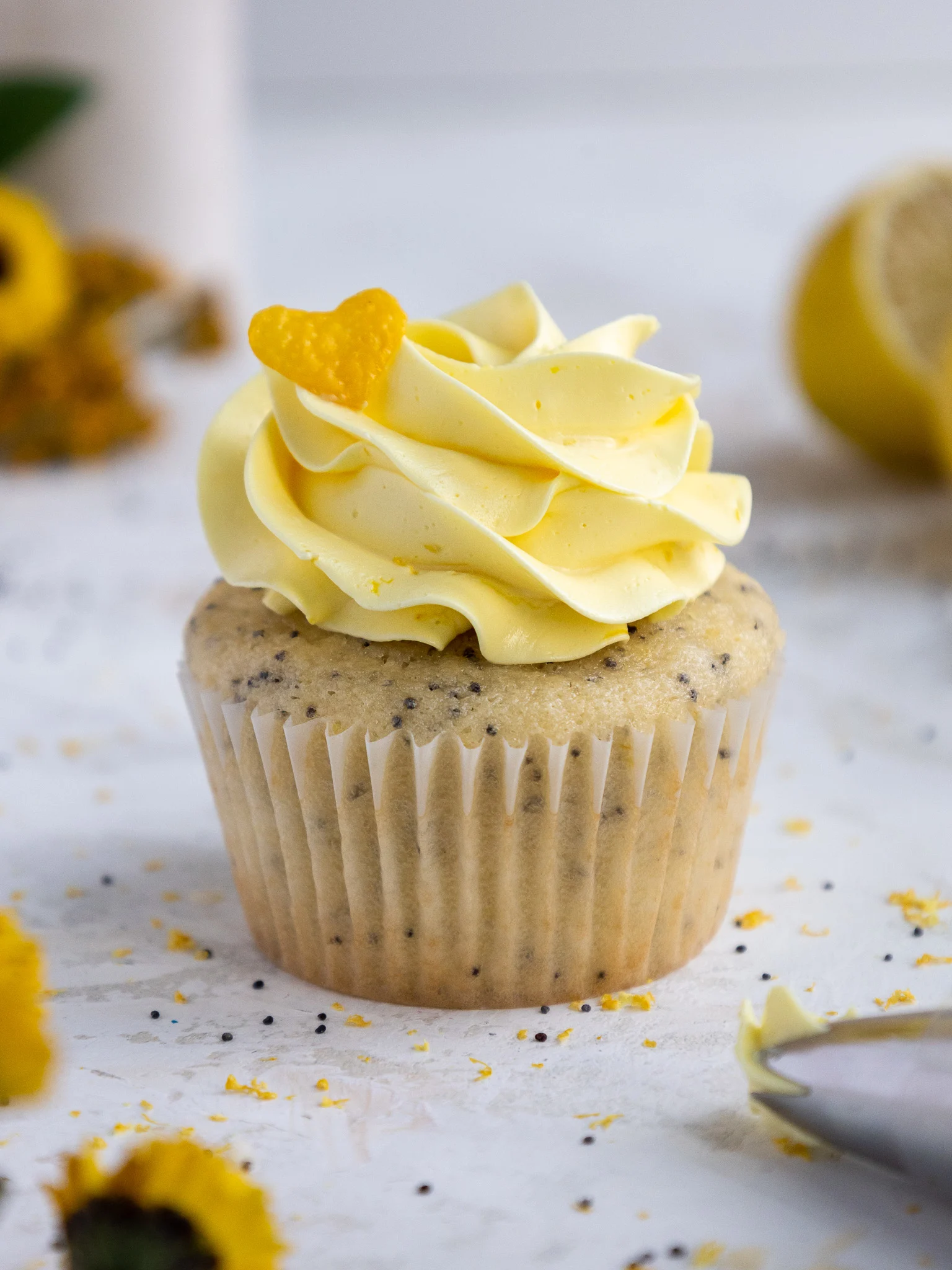 image of a poppy seed cupcake that's been frosted with lemon Swiss meringue buttercream