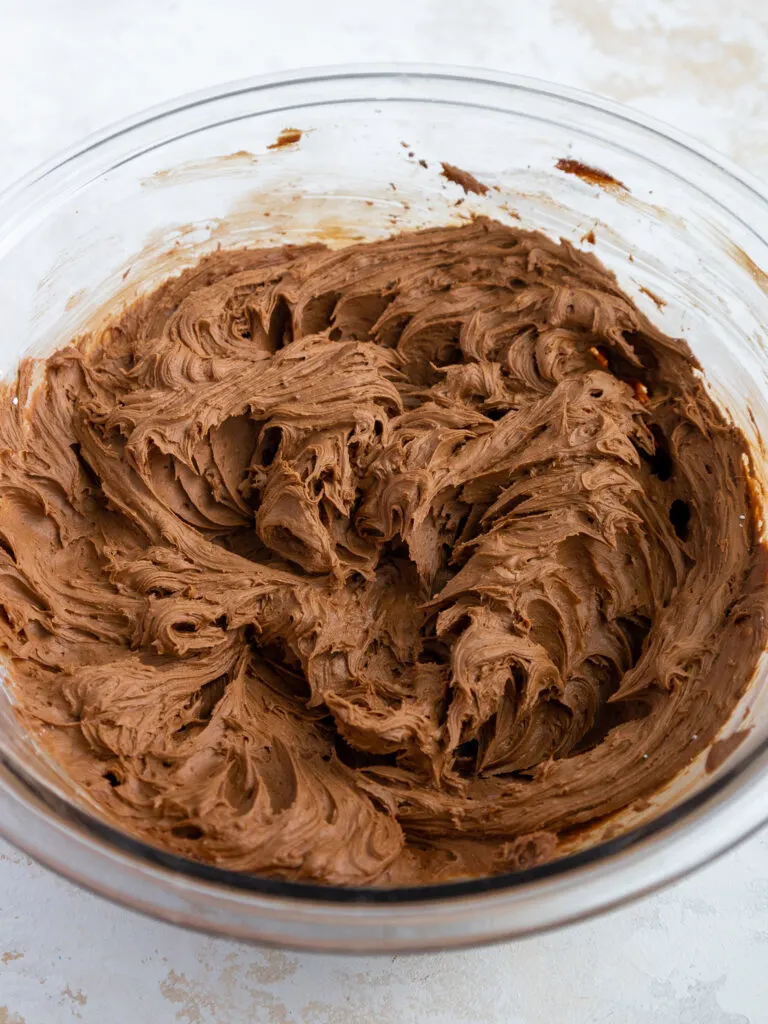 image of chocolate buttercream that's been mixed in a bowl to frost death by chocolate cupcakes