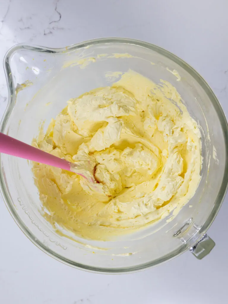 image of lemon swiss meringue buttercream that's been made in a glass mixing bowl