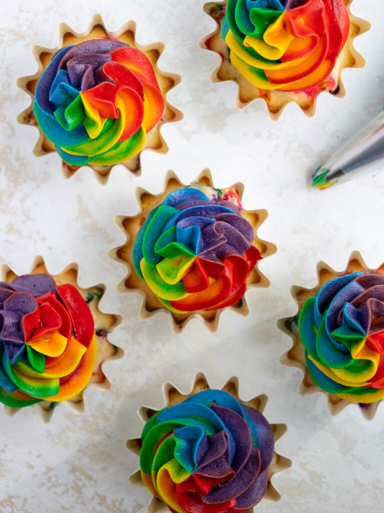 image of an overhead shot of rainbow frosting cupcakes