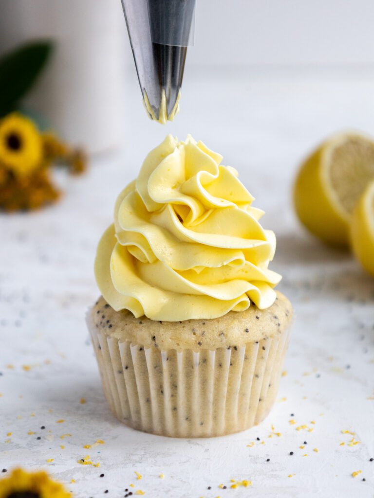 image of lemon Swiss meringue buttercream being piped onto a cupcake