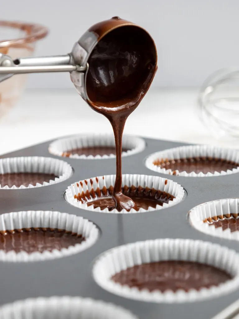 image of death by chocolate cupcake batter being scooped into cupcake liners to be baked