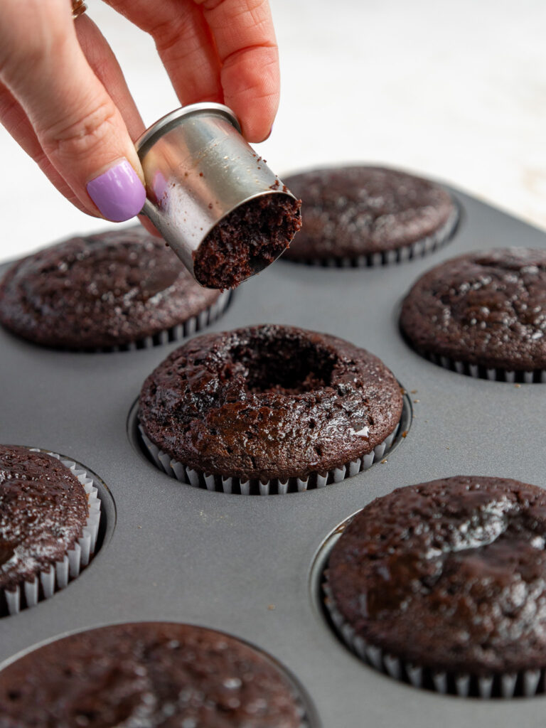 image of the center of a dark chocolate cupcake being cut out so that it can be filled with ganache