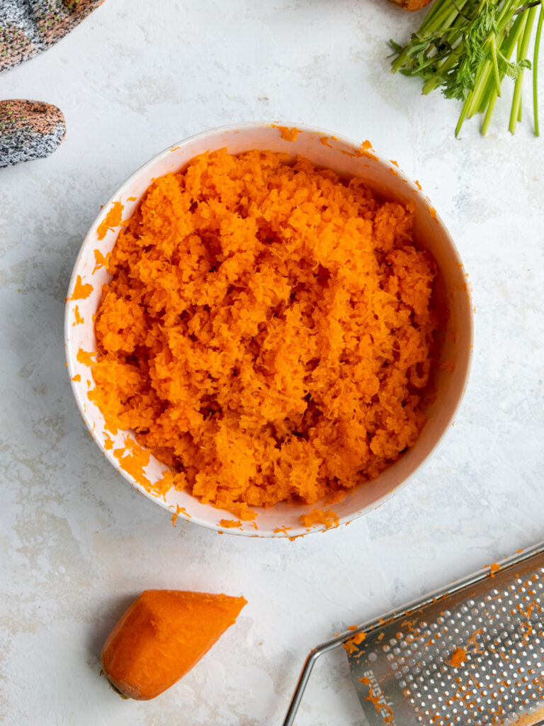 image of finely grated carrots in a bowl that's going to be used to make a 6 inch carrot cake recipe