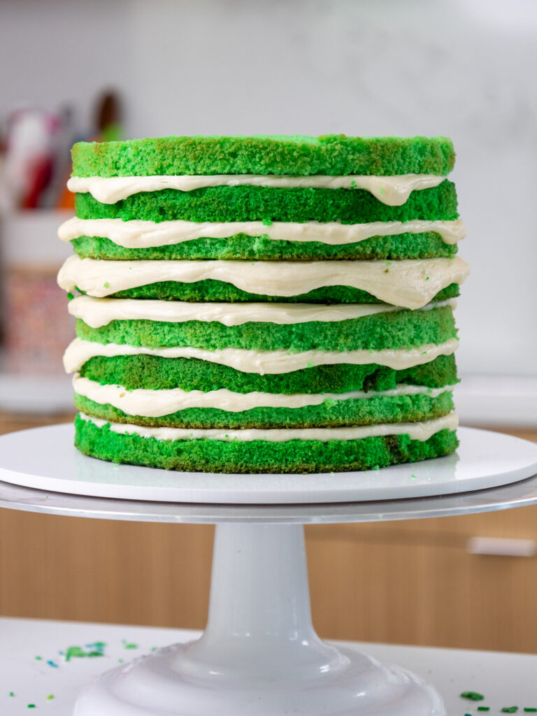 image of green velvet cake layers that have been filled with buttercream and are stacked