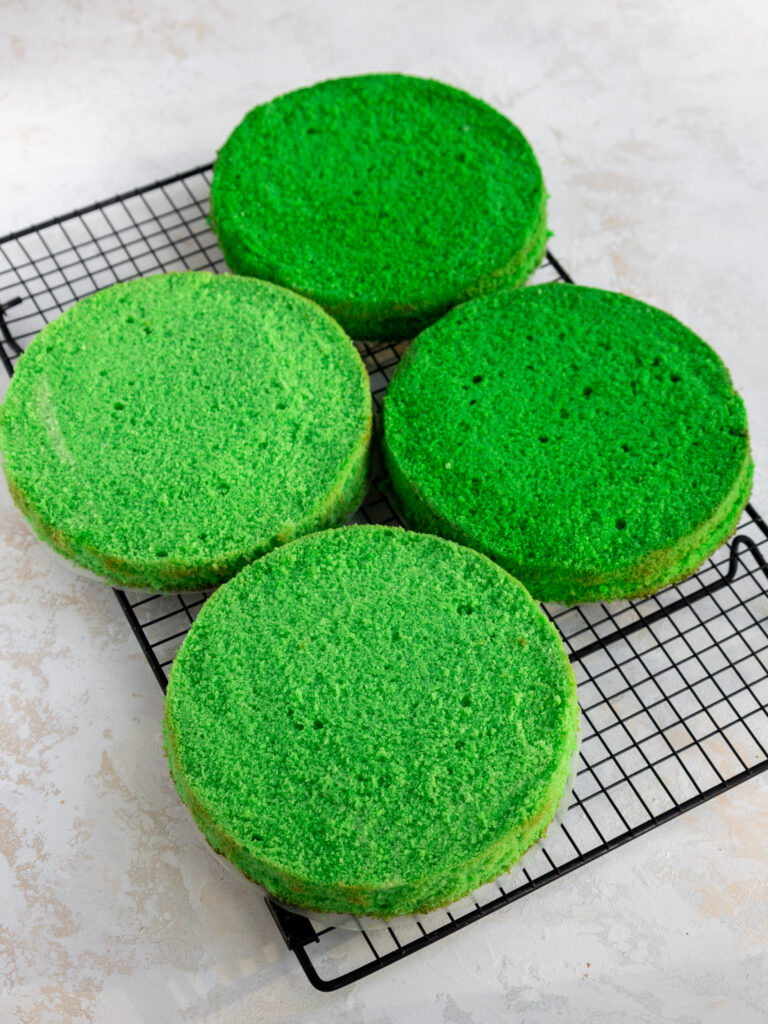 image of green velvet cake layer on a wire baking rack that have been leveled and trimmed