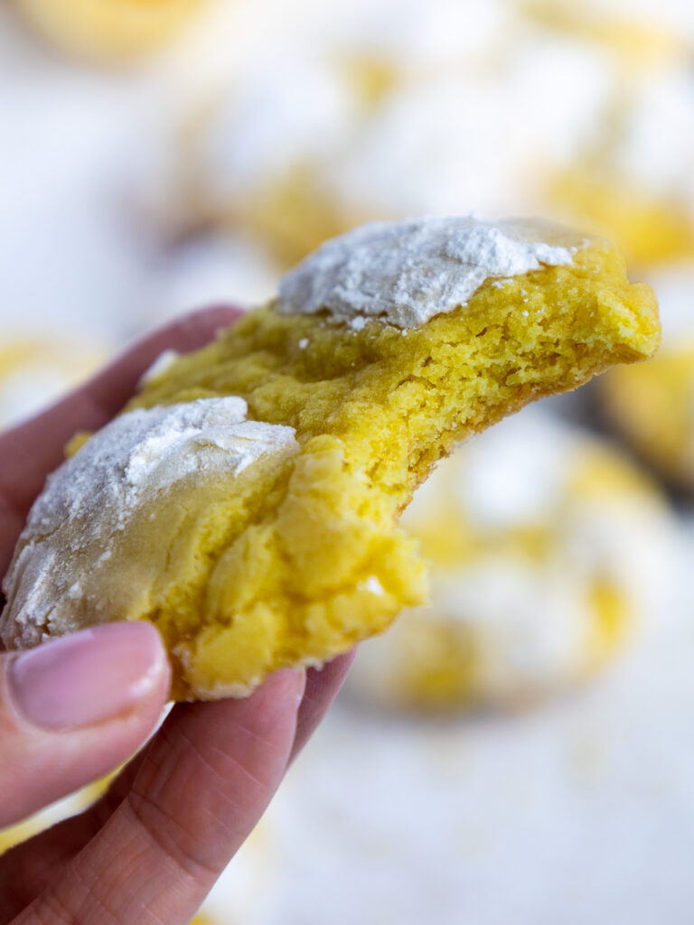 image of a lemon crinkle cookie that's been bitten into to show how chewy and soft it is