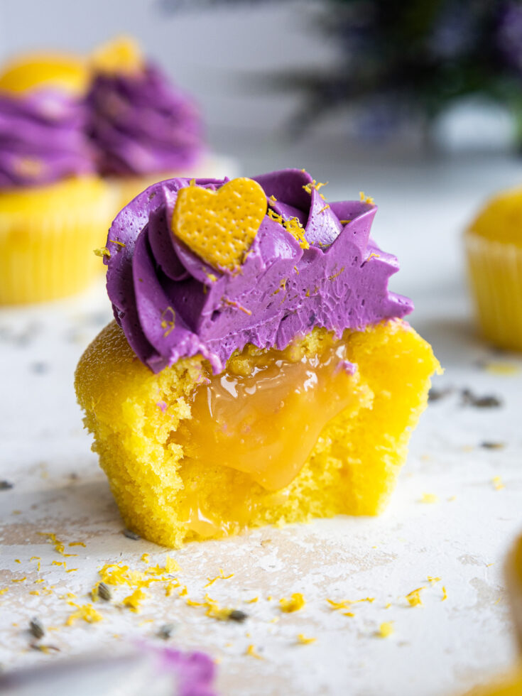 image of a lavender lemon cupcake that's been cut into to show its lemon curd filling