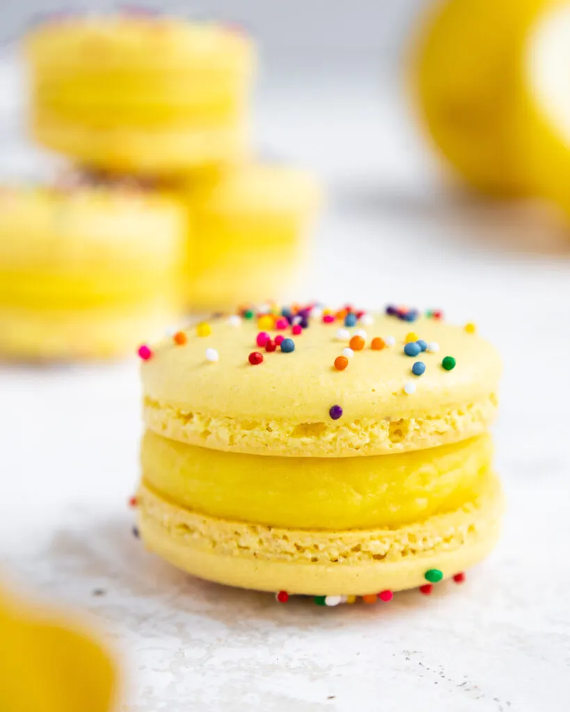 image of a yellow macaron filled with lemon ganache